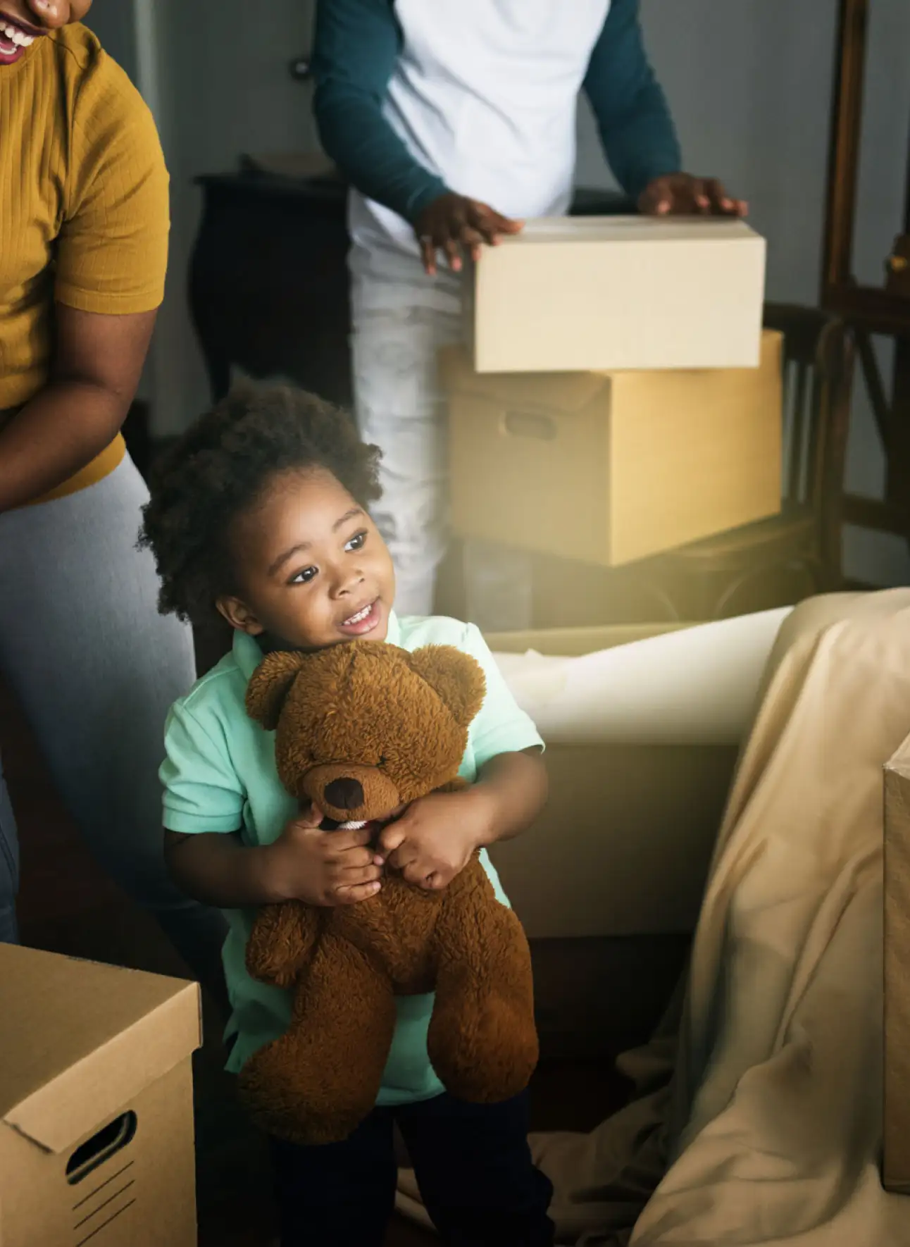 A little girl hoolding a teddybear and smiling